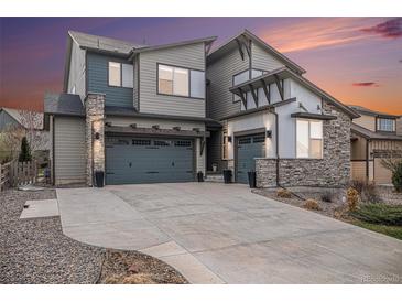 Modern two-story home features stone accents, a spacious driveway, and an attached two-car garage at 9342 Bear River St, Littleton, CO 80125