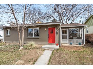 Charming home featuring a bright red front door, neutral stucco, and mature trees in a cozy front yard at 3270 S Washington St, Englewood, CO 80113