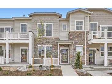 Attractive townhome showcasing stone accents, covered porch and landscaped front yard at 8887 San Antonio St, Littleton, CO 80125