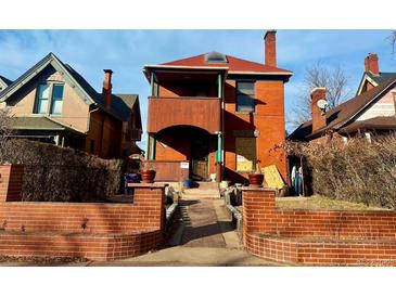 Charming home with a brick pathway leading to a covered porch and a red tiled roof at 241 W 4Th Ave, Denver, CO 80223