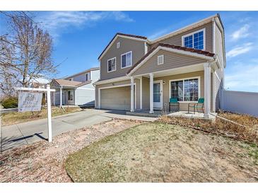 Charming two-story home with a covered front porch and attached garage in a residential neighborhood at 5214 Perth Ct, Denver, CO 80249