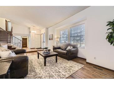 Bright living room with hardwood floors, large windows, and comfortable seating arrangement at 1348 E Jamison Ave, Centennial, CO 80122
