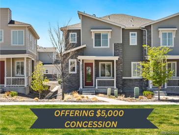 Charming two-story townhouse featuring stone accents, front porch and well-maintained landscaping at 23527 E 5Th Pl, Aurora, CO 80018