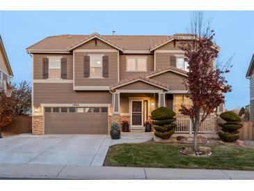 Two-story house with a large front yard, attached garage, and landscaping at 10918 Bellbrook Cir, Highlands Ranch, CO 80130