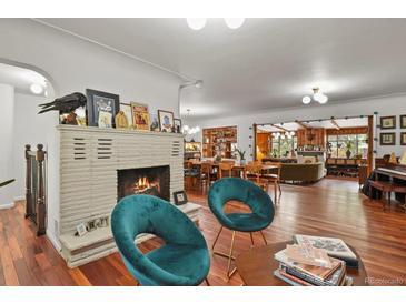 Spacious living room featuring a stone fireplace, hardwood floors, and stylish decor at 4040 Cody St, Wheat Ridge, CO 80033