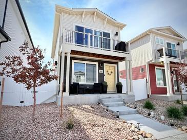 Charming two-story home with a balcony, landscaped front yard, and inviting entryway on a sunny day at 5027 N Walden Way, Denver, CO 80249