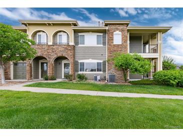 Multi-level townhouse with stone accents, manicured lawn, and inviting curb appeal at 6222 Kilmer Loop # 103, Golden, CO 80403