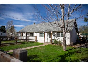 Charming home with a well-maintained front yard and a quaint wooden fence at 4087 S Clarkson S St, Englewood, CO 80113