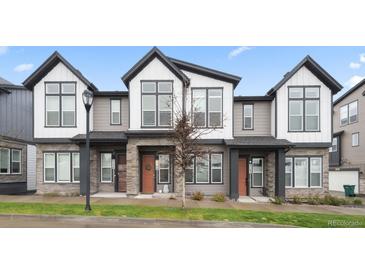 Modern townhomes featuring stone accents, neutral colors, and large windows for ample natural light at 5148 Taft Ct, Wheat Ridge, CO 80033
