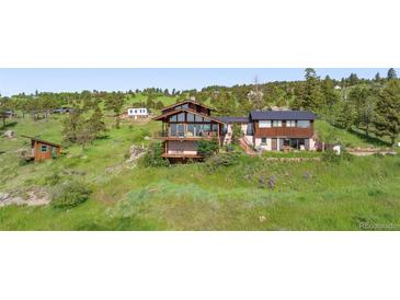 Stunning multi-level home on a hill with balconies and lush greenery at 393 Dixon Rd, Boulder, CO 80302