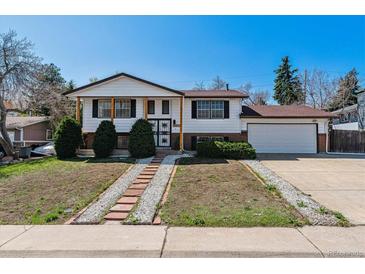 Charming two-story home with landscaped front yard and attached two-car garage on a sunny day at 13472 W Dakota Ave, Lakewood, CO 80228