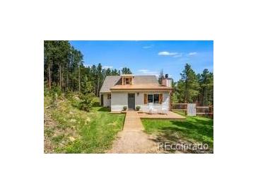 Charming home with a well-manicured lawn and a welcoming front porch at 9092 Gray Ln, Conifer, CO 80433