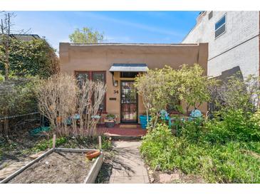 Charming home featuring a tidy front yard with flower beds and a cozy entrance at 34 W Maple Ave, Denver, CO 80223