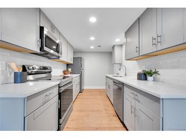 Modern kitchen with stainless steel appliances, white subway tile backsplash, and gray cabinetry at 1344 Sable Blvd, Aurora, CO 80011