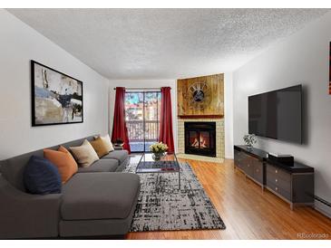 Cozy living room featuring a fireplace, balcony access, stylish decor, and comfortable seating at 14751 E Tennessee Dr # 225, Aurora, CO 80012