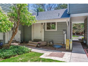 Charming front entrance of home with gray siding, a white door, and a small, well-maintained yard at 262 S Nome St, Aurora, CO 80012