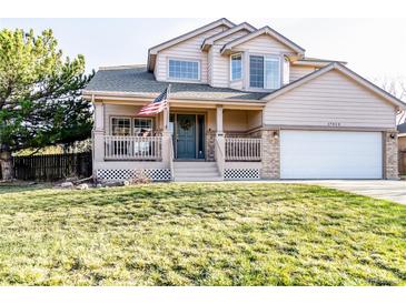 Charming two-story home with a covered front porch and well-maintained lawn, perfect for curb appeal at 17020 W 64Th Dr, Arvada, CO 80007