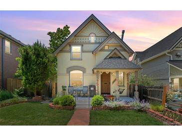 Charming two-story home with a well-manicured front yard and cozy front porch seating area at 2829 N Franklin St, Denver, CO 80205