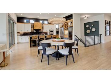 Bright dining room featuring modern chandelier, round table, and hardwood floors in a contemporary home at 3436 W 154Th Ave, Broomfield, CO 80023