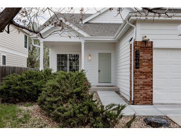 Inviting front entrance with brick accents, manicured landscaping, and a light green door at 4264 Thorndyke Pl, Broomfield, CO 80020