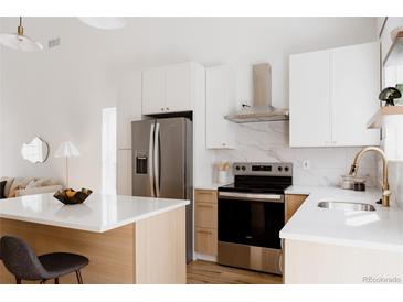 Bright kitchen featuring stainless steel appliances, white countertops, and light wood cabinets at 4264 Thorndyke Pl, Broomfield, CO 80020
