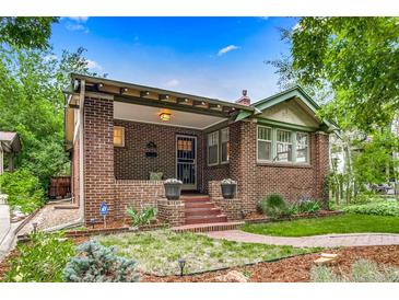 Charming brick home featuring a covered porch, red brick stairs, and lovely landscaped front yard at 840 S Corona St, Denver, CO 80209