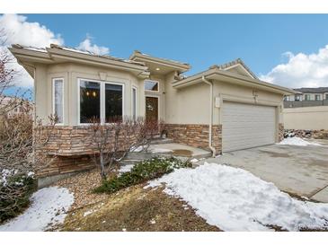 Charming exterior with stone accents, well-maintained landscaping, and attached garage at 2601 S Kipling Ct, Lakewood, CO 80227