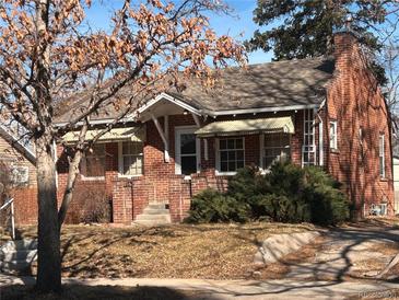 Charming brick home featuring a well-maintained lawn and mature trees with a classic architectural style at 2134 S Corona St, Denver, CO 80210