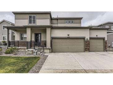 Two-story home with neutral siding, a multi-car garage, and a covered front porch at 12749 Horton Ct, Parker, CO 80134