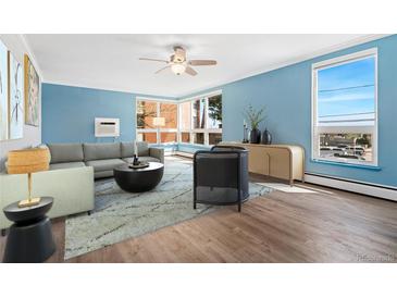 Bright living room with large windows, hardwood floors, ceiling fan, and comfortable furniture at 320 S Ames St # 5, Lakewood, CO 80226