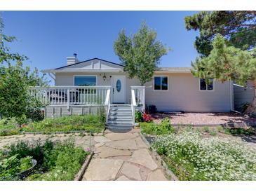 Charming single Gathering home featuring a welcoming front porch, manicured landscaping, and stone walkway leading to the front door at 45321 Summit Rd, Parker, CO 80138