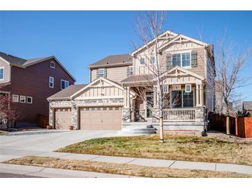 Charming two-story home with a covered porch, three-car garage, stone accents, and well-maintained landscaping at 30 Stewart Way, Erie, CO 80516