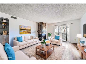 Inviting living room features a stone fireplace and sliding doors to the outside at 922 S Walden Street St # 103, Aurora, CO 80017