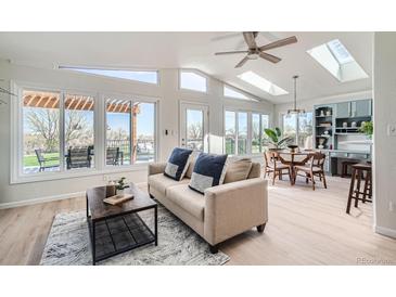 Bright living room with large windows, vaulted ceilings, and an open concept design leading to an outdoor patio at 5855 Rustic Knolls Dr, Boulder, CO 80301