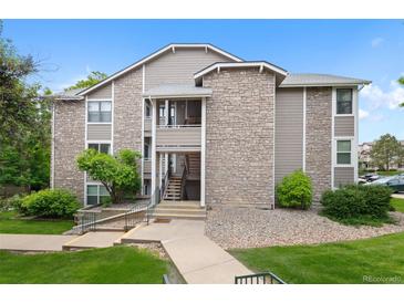 Multi-level condo building featuring stone and siding, plus mature landscaping at 8378 S Upham Way # B205, Littleton, CO 80128