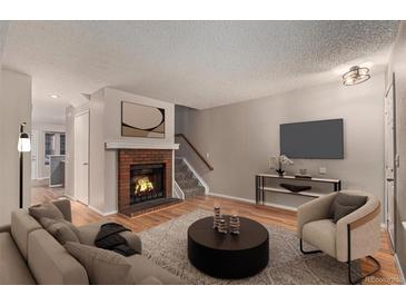 Inviting living room featuring a cozy fireplace, modern decor, and hardwood floors at 18577 E Whitaker Cir # C, Aurora, CO 80015