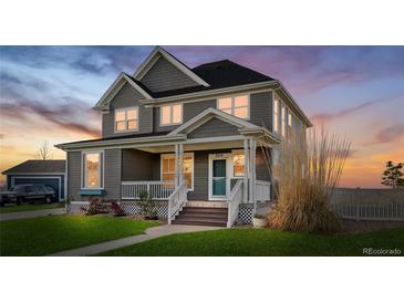 Charming two-story home featuring a welcoming front porch, manicured lawn, and traditional design elements at 9515 E 109Th Cir, Commerce City, CO 80640