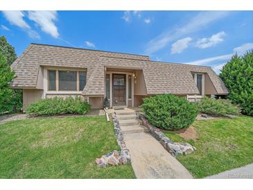 Charming home featuring a unique roofline, well-manicured lawn, and inviting stone walkway leading to the front door at 31 Irene Ct, Broomfield, CO 80020