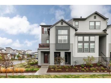 Attractive townhome with a charming covered front porch and professional landscaping at 6303 Elmira St, Denver, CO 80238