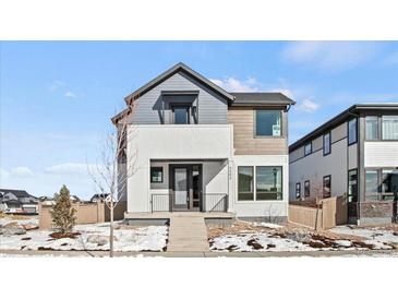 Modern two-story home featuring mixed siding, a small front porch, and landscaped front yard with some snow at 5584 Moosehead Cir, Longmont, CO 80504
