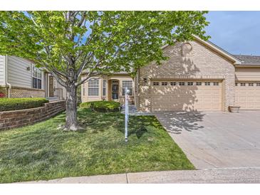 Charming brick home with manicured lawn, mature tree, and a three-car garage at 29 Woodland Cir, Highlands Ranch, CO 80126