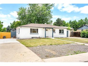 Charming exterior view of a renovated home with a fresh white paint job and landscaped front yard at 6500 W 32Nd Ave, Wheat Ridge, CO 80033