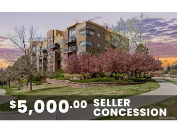 A multi-story condo building with balconies, professional landscaping, and mature flowering trees provides a serene outdoor atmosphere at 9019 E Panorama Cir # D204, Englewood, CO 80112