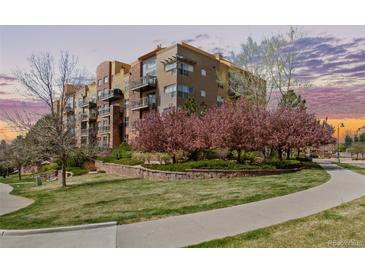 Beautiful condo building with lush landscaping and manicured grounds on a sunny day at 9019 E Panorama Cir # D204, Englewood, CO 80112