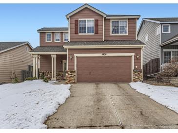 Two-story brown house with a two-car garage and snow-covered driveway at 4936 Stoneham Ave, Castle Rock, CO 80104