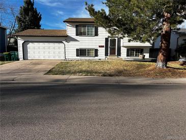 Charming two-story home with a two-car garage and a well-maintained front lawn at 9135 W Maplewood Ave, Littleton, CO 80123