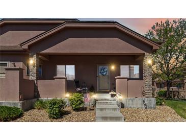 Charming front porch featuring stone pillars, decorative lighting, and a welcoming entrance at 15501 E 112Th Ave # 20C, Commerce City, CO 80022