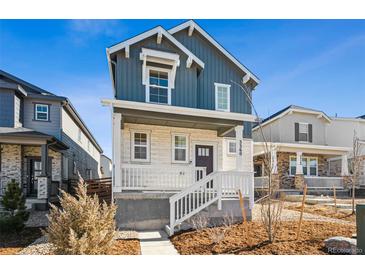 Charming two-story home featuring a welcoming front porch and blue siding on a sunny day at 3360 N Coolidge Way Way, Aurora, CO 80019