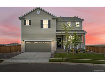 Charming two-story home with a well-manicured lawn and an attached two-car garage at 17424 E 90Th Pl, Commerce City, CO 80022