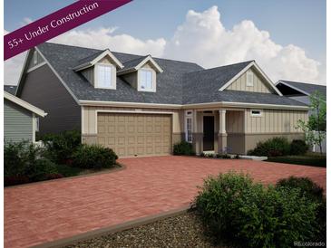 Two-story craftsman style home with a two-car garage and inviting front porch at 21937 E 51St Dr, Aurora, CO 80019